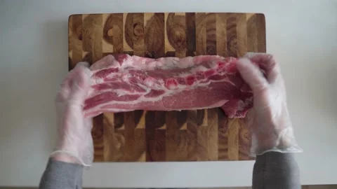 A large piece of ribs is placed on a cutting wooden board Stock Footage 169834818