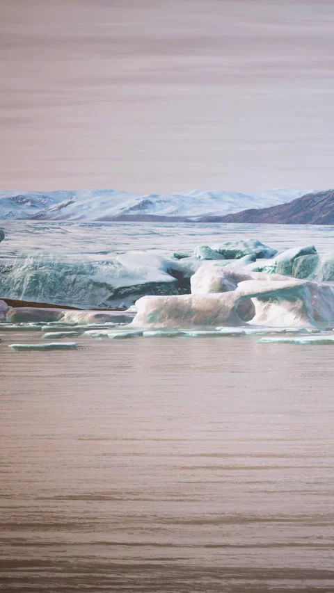 Large pieces of ice break away from a glacier and fall into the water Stock Footage 346756823