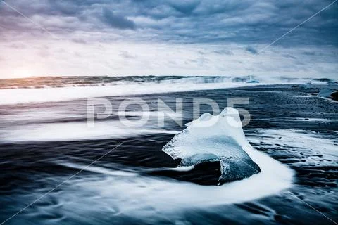 Large pieces of the iceberg that sparkle on the black sand. Location place Jo Stock Photos