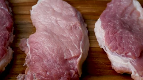 Large pieces of pork meat on a kitchen wooden board. Stock Footage 311309514
