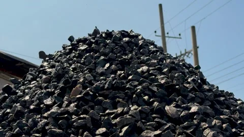 Large pile of black coal against a clear blue sky with electrical poles in .. Stock-Footage 339296421