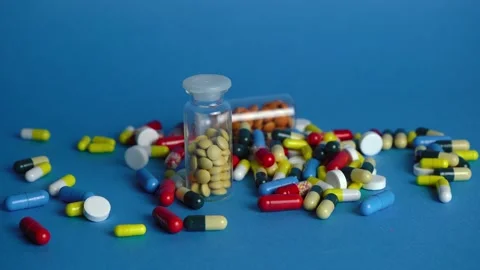 Large pile of pills on blue background Stock Footage 144185445