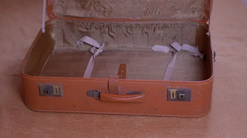 Large Pile of Things Thrown into an Open Old Suitcase Along with a Mask. 4K Video stock 154326129