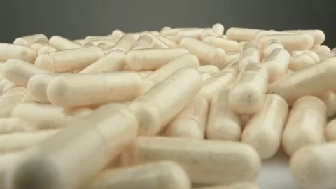 A large pile of white capsules is displayed in close up, highlighting the 库存影片 341034841