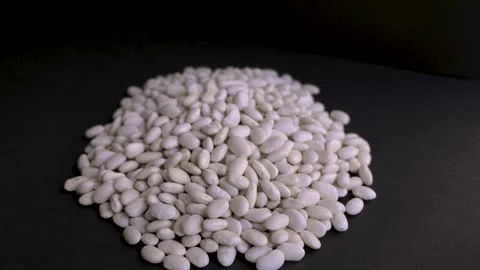 Large pile of white lima beans on black background 4k 10bit 120fps Видео 332713105