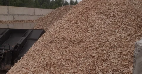 Large pile of wood chips beside industrial loader in outdoor storage yard 스톡 동영상 346315846