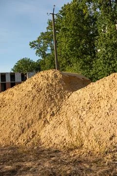 Large piles of sand at a construction site with an unfinished building and .. Stock Photos