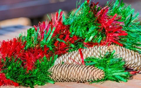 Large pine cones with red and green Christmas tinsel Stock Photos