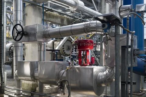 Large pipe with a red valve on it Stock Photos
