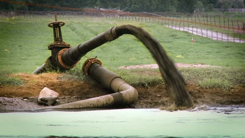 A large pipe from which dirty water flows. River of dirty water. Environmental Stock Footage 102662041