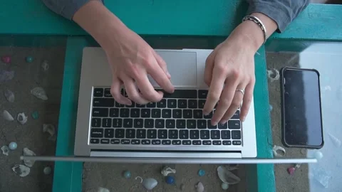 A large plan of women's palms that fluently enter text on a laptop Video stock 234023100