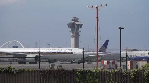Large planes moving around next to tower at LAX airport Stock Footage 89186757