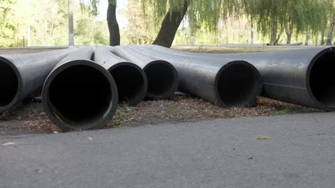 Large plastic black pipes lie on the ground outside. Stock Footage 286026652