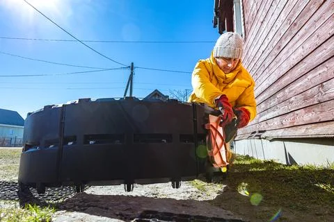 Large plastic composter under construction beside wooden house as gardener .. Stock Photos