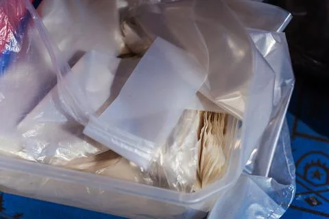 A large plastic container that is filled to the brim with numerous plastic ba Stock Photos