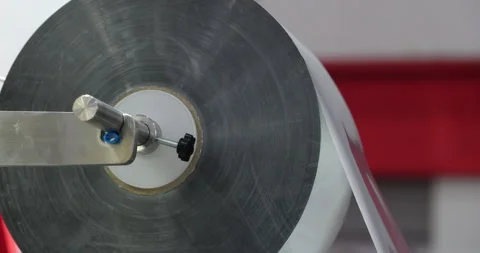 Large plastic film roll mounted on industrial machine for packaging Stock Footage 346704540