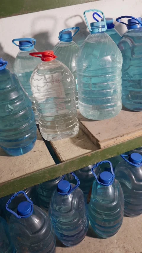 Large Plastic Water Bottles Stored on Wooden Shelves in Basement Pantry Video stock 335646890