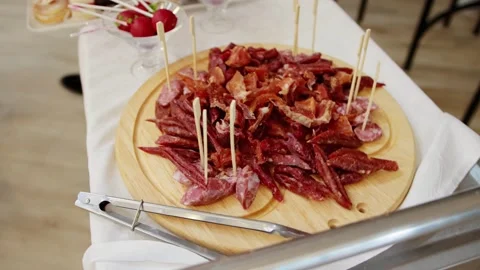 A large plate of different types of sausages and meats on a table in a Stock Footage 264022233