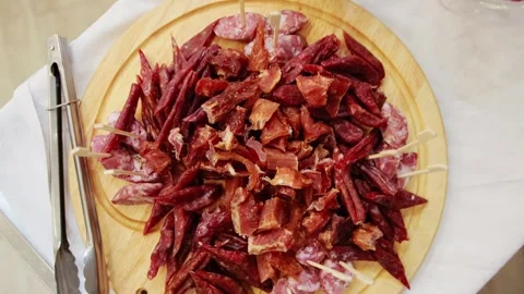 A large plate of different types of sausages and meats on a table in a Stock Footage 264768305