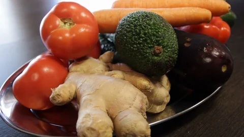 Large plate with fresh vegetables. ginger, carrots, tomatoes, eggplant, avocado Stock Footage 122411831