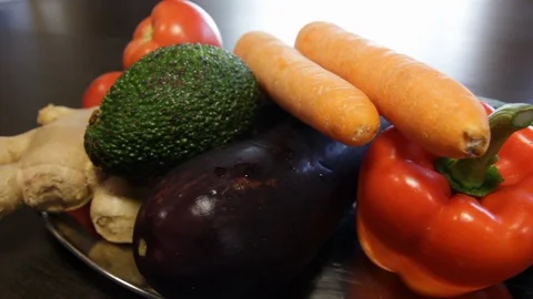 Large plate with fresh vegetables. ginger, carrots, tomatoes, eggplant, avocado Stock Footage 122411931