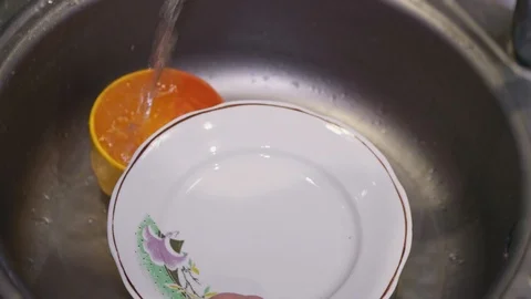 A large plate is washed in the sink with detergent close up Video stock 104380515