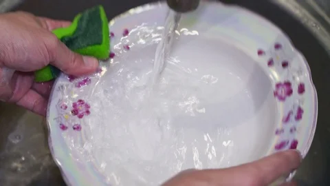 A large plate is washed in the sink with detergent Stock Footage 104380595