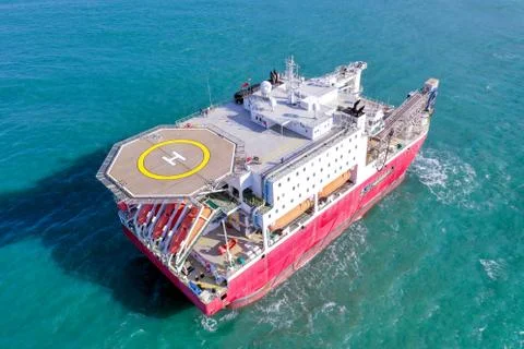 Large Platform supply ship with Helipad and two large cranes, anchored at Sea. Stock Photos