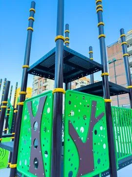 A large playground structure stands in an urban area under a clear blue sky.  Stock Photos