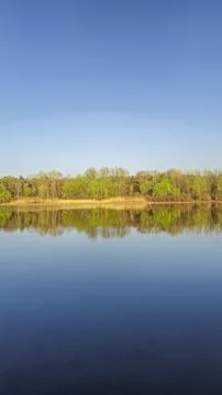 Large pond surrounded by trees and plants. Camping. Spring landscape. Фото