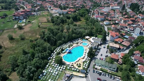A large pool with many umbrellas and people in the water, aerial shot The poo Video stock 347175921