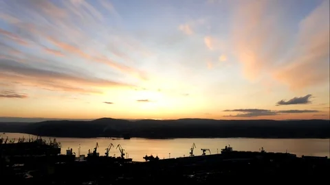 A large port and a bay in the background of the setting sun, timelapse. Stock Footage 83160035