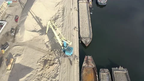 Large port cranes  unload the river sand barge onto a large heap. Stock Footage 150702126