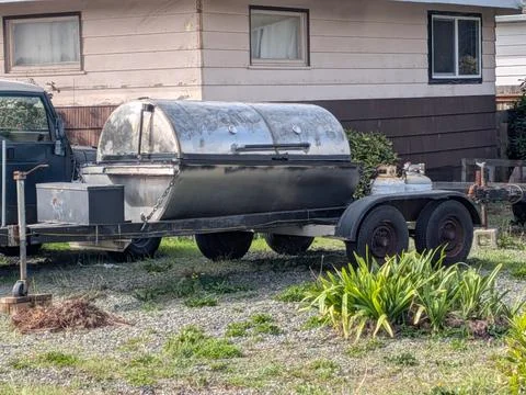 Large portable silver BBQ grill on a two-wheel trailer, ideal for outdoor feasts Stock Photos