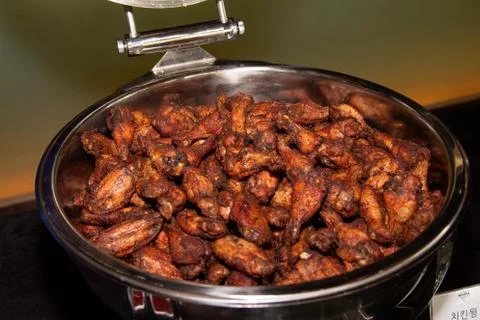 Large portion of fried chicken wings stacked on a buffet tray. Stock Photos