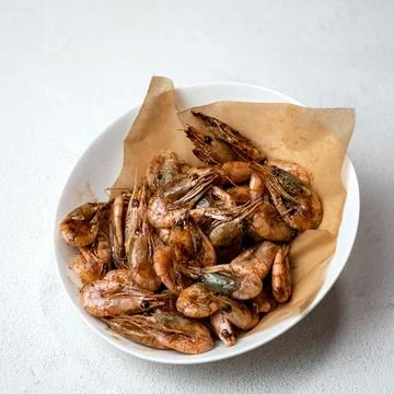 Large portion of fried shrimp or prawn on parchment paper. Top view of White Stock Photos