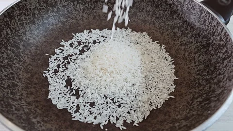 Large portion of steaming white rice being stirred in a commercial kitchen pot Stock Footage 339078876