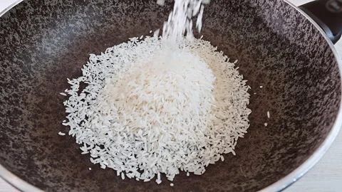 Large portion of steaming white rice being stirred in a commercial kitchen pot Stock Footage 341441064
