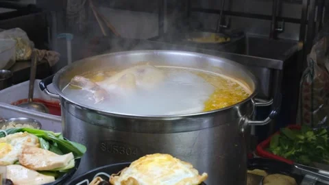 Large pot with boiling chicken broth and whole bird at street food stall Stock Footage 336442204