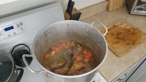 Large pot of simmering broth with previously roasted Duck as main ingredient Stock Footage 104247587