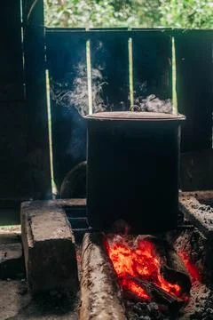 Large pot steaming over glowing firewood Stock Photos