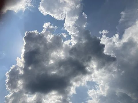 A large, potentially threatening dark cloud dominates an image with scatter.. Stock Photos