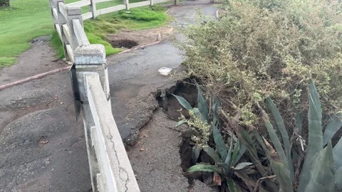 Large pothole in a flat park area with sparse vegetation, Santa Monica Stock Footage 345265949