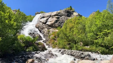 A large, powerful, beautiful waterfall in the mountains. Caucasus, Dombai.  Stock Footage 283899806
