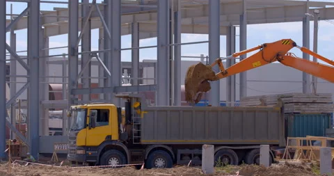 A large, powerful, multi-axle truck is loaded the earth by an excavator Stock Footage 161985090