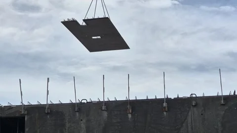 Large precast concrete floor panel hoisted above building under construction 스톡 동영상 342049824