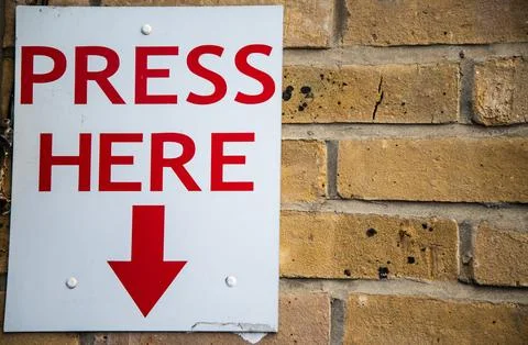 Large "PRESS HERE" sign in bold red letters Stock Photos