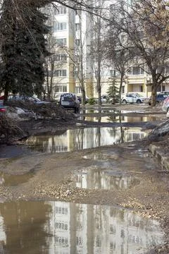 A large puddle in the courtyard of a  building in the spring Stock Photos