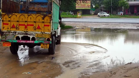 Large puddle on a dirt sandy road. Untarred and Muddy Road During Rainy Seaso Stock Footage 220692304
