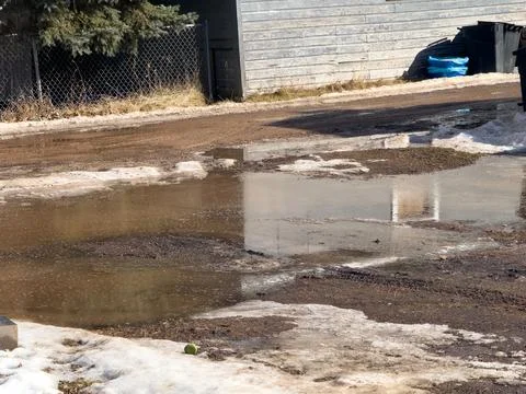 A large puddle in the driveway during spring melt Stock Photos